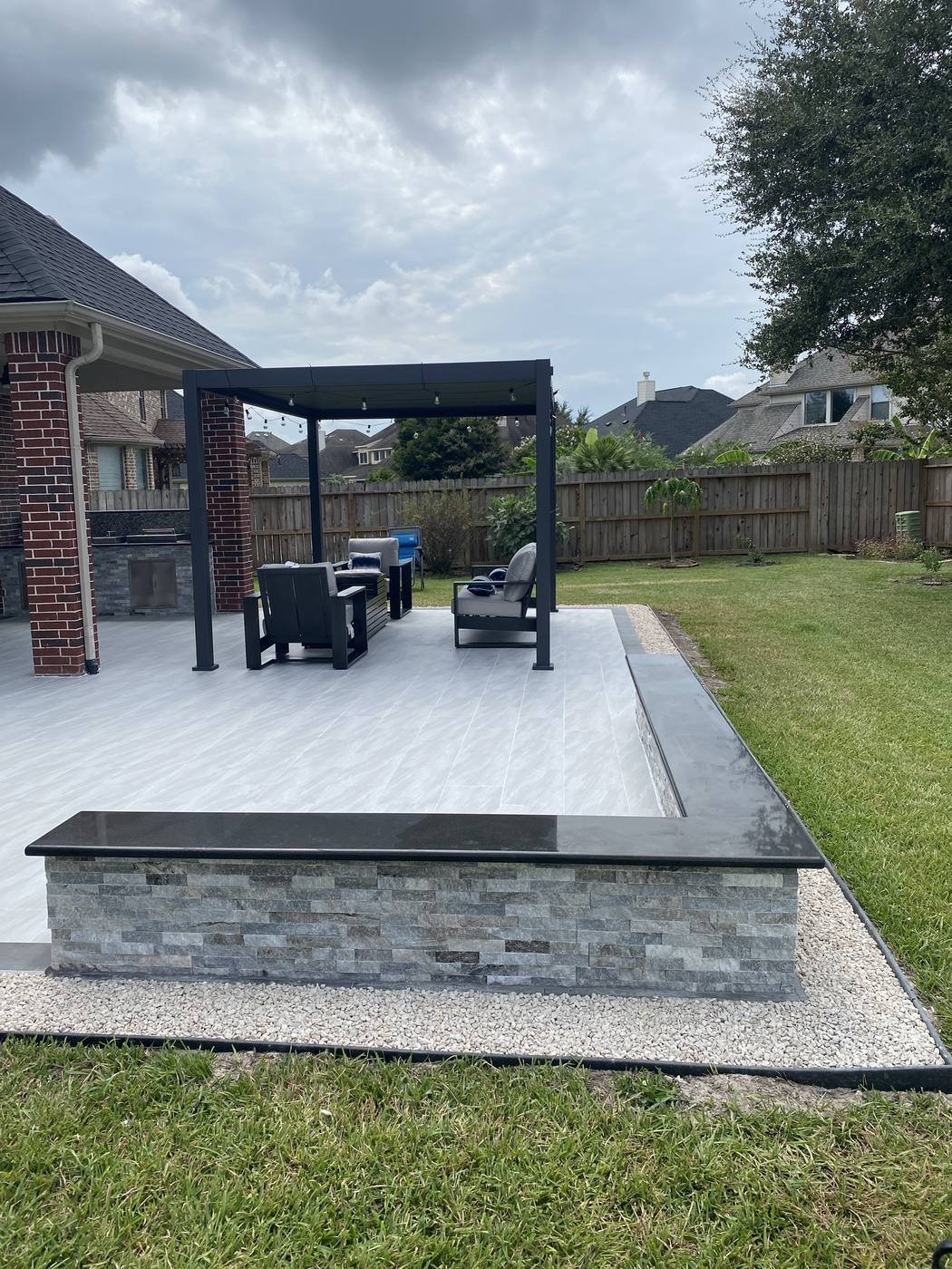 Large paver patio with pergola and outdoor kitchen bar