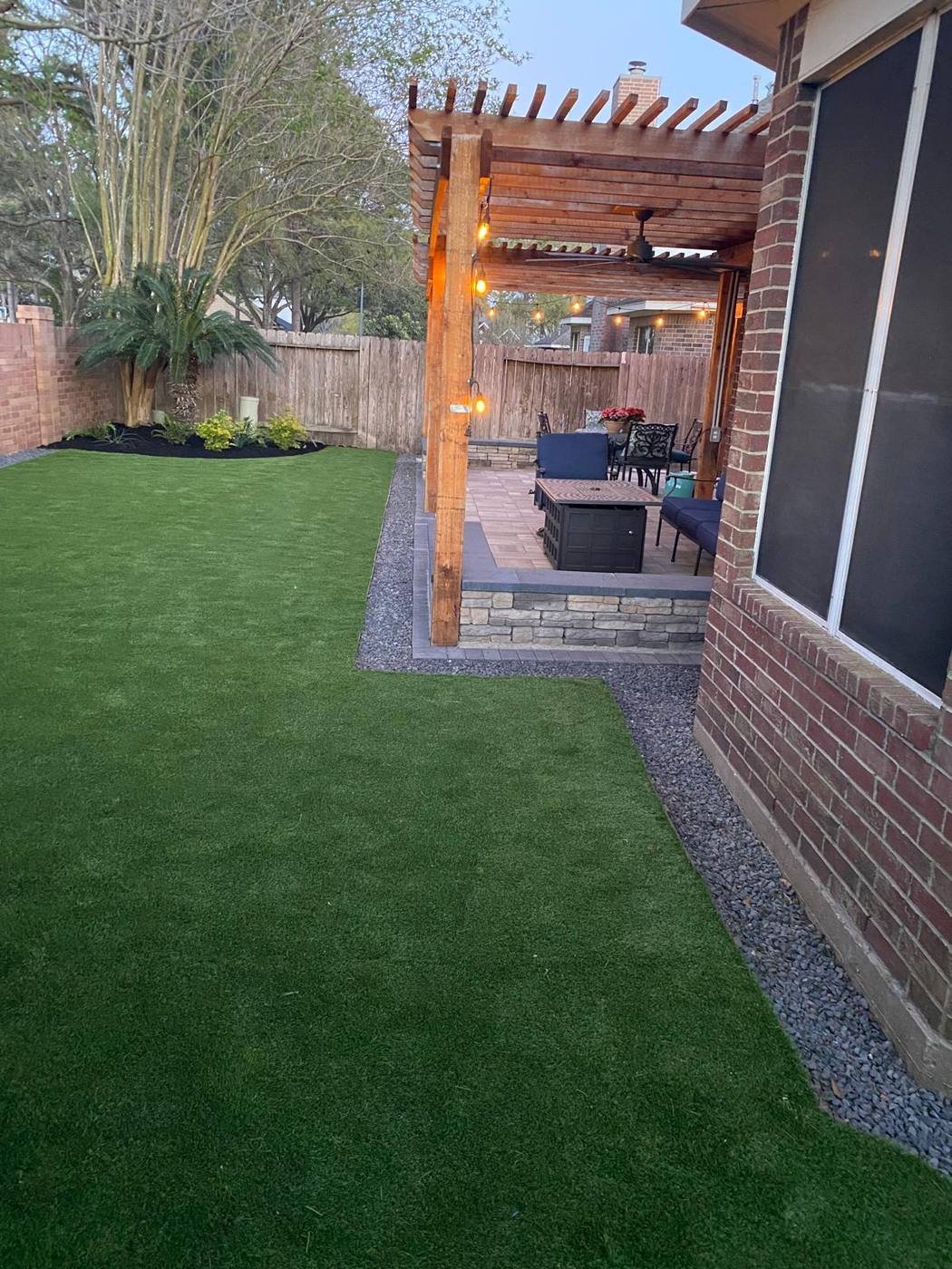 Backyard synthetic turf lawn with a cedar pergola patio